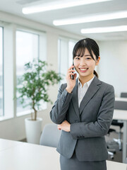 Confident Businesswoman in Gray Suit Handling Phone Call in Office