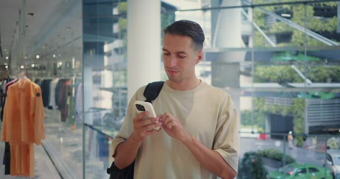 Man with smartphone comparing deals overseas, enthusiastic shopper browsing options for unique souvenirs. Confident shopper finalizing cross-border purchases, perfect for global retail content.