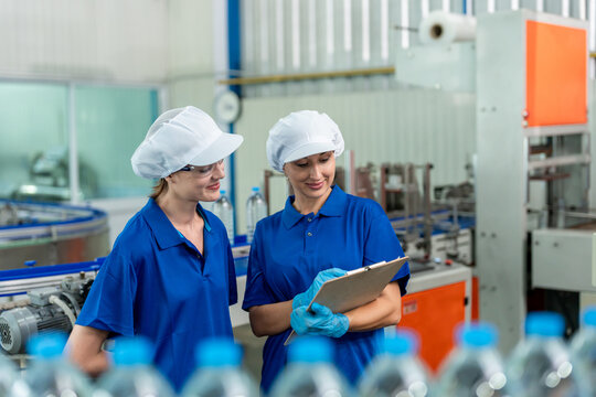 Caucasian female industry worker team working in factory warehouse. 