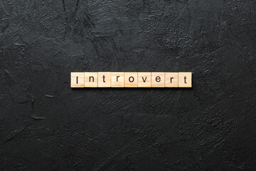 Introvert word written on wood block. Introvert text on table, concept