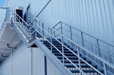 A set of stairs ascending a large blue wall