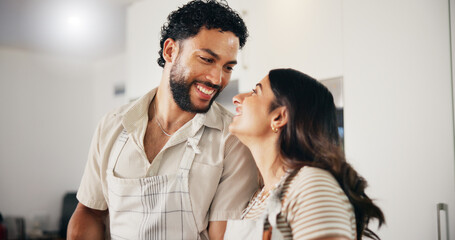 Obraz premium Home, cooking and couple in kitchen, funny and bonding together with apron, romance and marriage. People, relationship and man with woman, happiness and healthy meal with smile, lunch and love