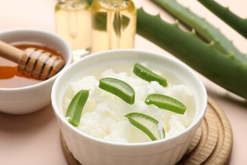 Hair treatment. Coconut, butter shavings, honey, cosmetic product and aloe leaves on beige background, closeup