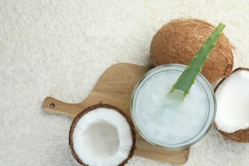 Refreshing drink with coconut and aloe on white textured table, flat lay