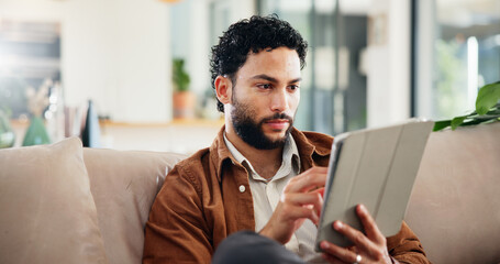 Man, relax and reading on sofa with tablet, social media and ebook for information in home. Person, network or tech in living room for streaming subscription, email notification and download new app