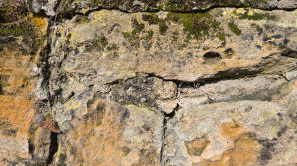 Old stone wall background of ancient ruined facade brown stones