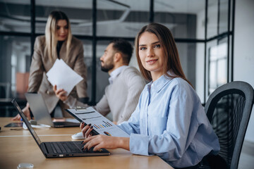 Documents in hands. Professional workers are in the modern office together
