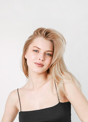 Fototapeta premium Portrait of a smiling beautiful blonde in a black top.