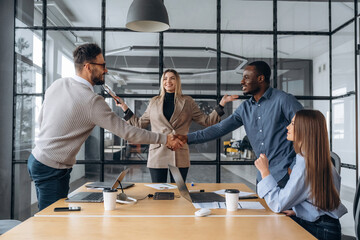 Cooperation, doing handshake. Professional workers are in the modern office together