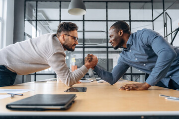 Two office workers are having fun and doing arm wrestling