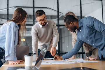 Fototapeta premium Together by the table. Professional workers are in the modern office