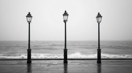 Grey Sea, Foggy Coast, Three Street Lamps. Possible Use Stock photo for a travel or nature-themed publication