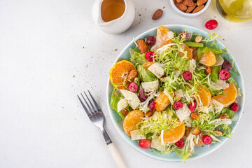 Salad bowl with lettuce, tangerines, nuts and cranberry