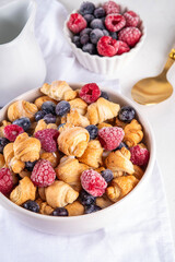 Tiny breakfast croissant cereals with fresh berries and milk