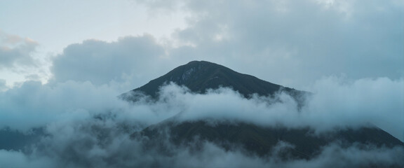 Dramatic mountain peak shrouded in swirling fog, nature's mystery