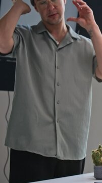 Vertical shot of young film director talking emotionally to unrecognizable actess, while discussing script on set