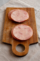Organic Smoked Cold Cuts Deli Meat Ham on a wooden board, side view.