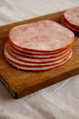 Organic Smoked Cold Cuts Deli Meat Ham on a wooden board, side view.
