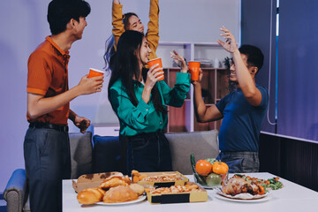 Happy young friends group having lunch at home. Asia family party eating pizza food and laughing enjoying meal while sitting at dining table together at house. Celebration holiday and togetherness.