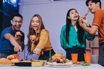Happy young friends group having lunch at home. Asia family party eating pizza food and laughing enjoying meal while sitting at dining table together at house. Celebration holiday and togetherness.