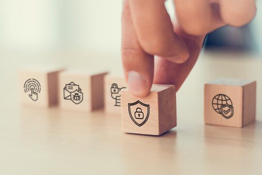 Hand with cybersecurity icons on  wooden blocks. Advanced technology, artificial intelligence, online privacy, data protection, security payment, network security, access control and SSL.