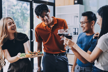 Asian office colleagues and friends enjoy a daytime BBQ with pizza and beer, celebrating Halloween and cheering for their favorite soccer team, creating a lively atmosphere filled with joy.