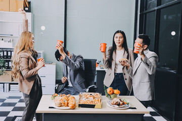 Asian office colleagues and friends enjoy a daytime BBQ with pizza and beer, celebrating Halloween and cheering for their favorite soccer team, creating a lively atmosphere filled with joy.