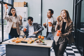 Asian office colleagues and friends enjoy a daytime BBQ with pizza and beer, celebrating Halloween and cheering for their favorite soccer team, creating a lively atmosphere filled with joy.