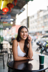 young woman talking on mobile phone in cafe