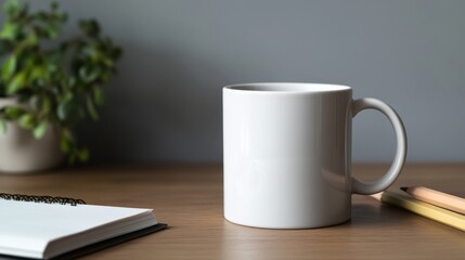 Blank white mug on wooden table, plant, notebook