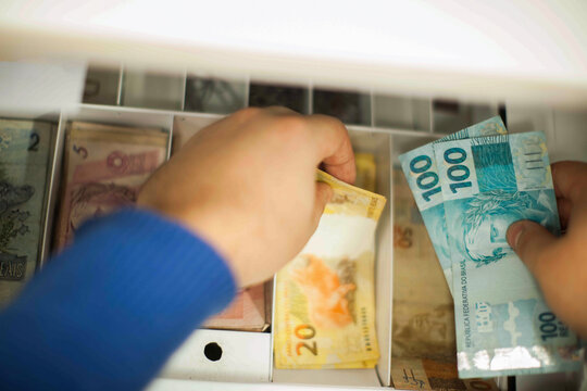 Businessman counting and exchanging money - Brazilian Real - Reais.