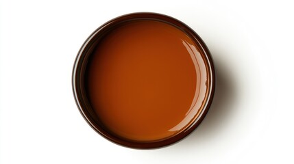 Brown liquid in round ceramic bowl on white background. Possible use food product presentation, cosmetics, pharmaceutical product