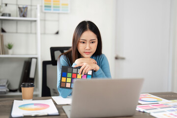 Color Theory and Design Choices. A woman analyzing color palettes on her laptop, immersed in a...