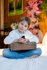 Cute sweet little blond child, toddler boy, playing with little chicks at home, baby chicks and child