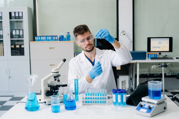 Naklejka premium male scientist working with micro pipettes analyzing biochemical samples, advanced science