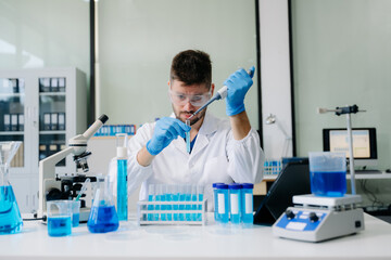 male scientist working with micro pipettes analyzing biochemical samples, advanced science