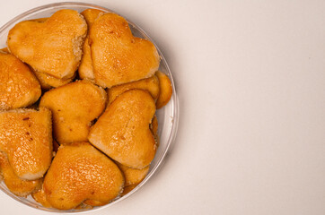 Golden heart-shaped peanut cookies arranged in clear bowl, highlighting sweet and delicious treats