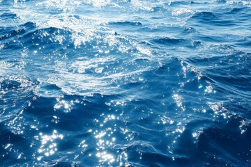 Obraz premium Waves sparkle under sunlight on a clear blue sea in an idyllic coastal setting during midday hours