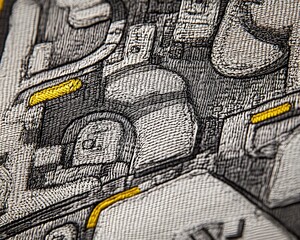 Close-up of intricate gray and yellow embroidered textile.