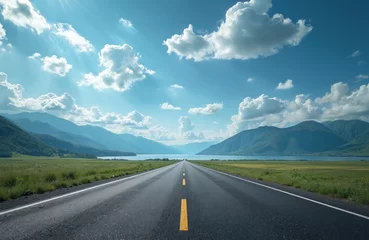 Asphalt road leads towards mountains, lake under blue sky with fluffy clouds. Scenic route, highway through beautiful nature, perfect for travel, journey, vacation. Empty road, scenic panorama view.