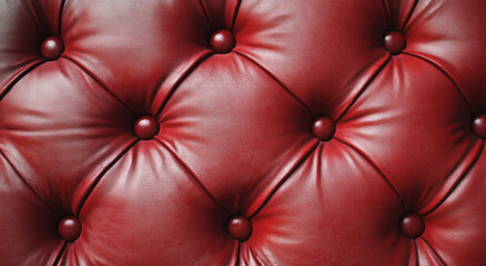Obraz premium Luxurious red leather upholstery with tufted design and round buttons, adding elegance to any space
