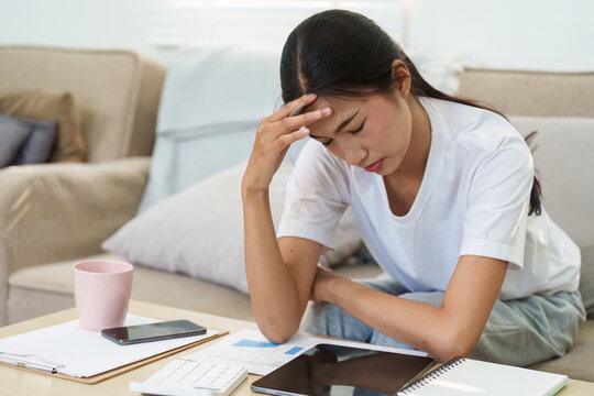 Challenges and Remote Work. A young woman feeling stressed while managing work tasks at home.