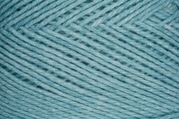 A close-up texture shot of blue yarn with diagonal stripes