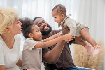 Fototapeta premium Family bonding time at home with children enjoying playful interaction in bright living room