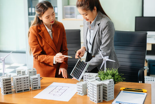 Professionals for a greener future. Showcasing renewable energy solutions with solar panels, wind turbines, and a model house.