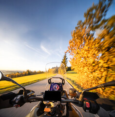 Detail of motorcycle handlebars. View from driver perspective, beautiful rural landscape in sunset...