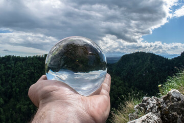 a glass ball that reflects mountains and plants