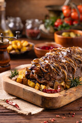 Roasted whole pork neck. Stuffed with onion slices. Served with baked potatoes.