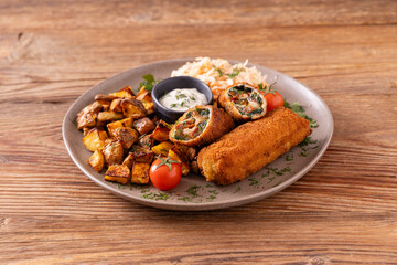 Pork chop rolls stuffed with spinach and mozzarella. Served with sun-dried tomatoes and roasted potatoes.