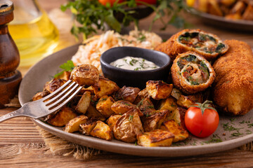 Pork chop rolls stuffed with spinach and mozzarella. Served with sun-dried tomatoes and roasted potatoes.
